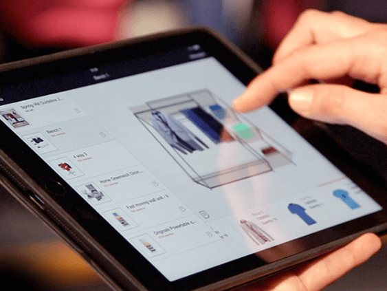 Photograph of person using the Visual Merchandising Software on an iPad to see how they need to VM and organise their retail store.